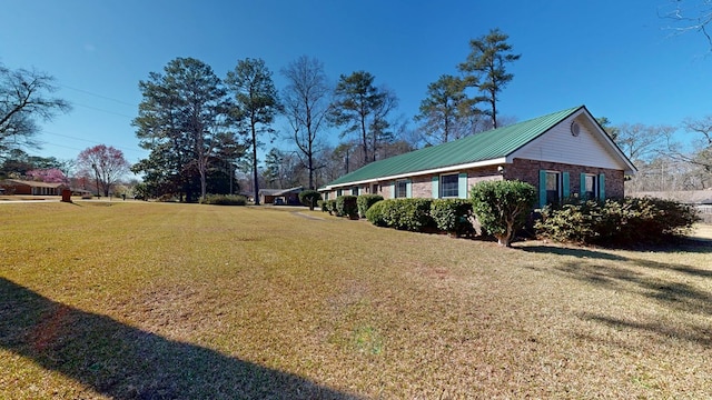 view of side of property with a lawn and brick siding