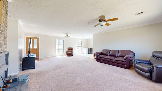 carpeted living area featuring visible vents, crown molding, a fireplace, a textured ceiling, and a ceiling fan