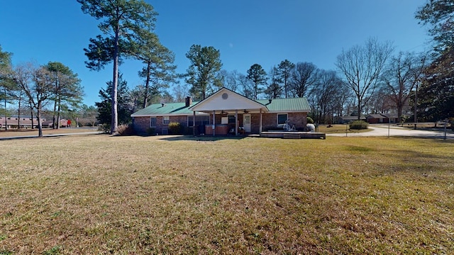 view of front of property with metal roof and a front yard