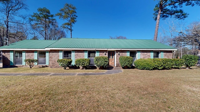 single story home featuring brick siding, metal roof, and a front yard