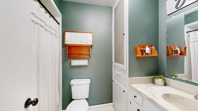 bathroom with toilet, vanity, and a textured ceiling