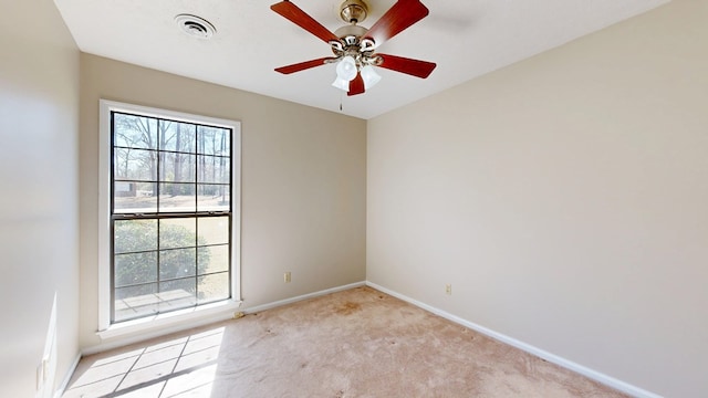 unfurnished room featuring visible vents, light carpet, baseboards, and a ceiling fan