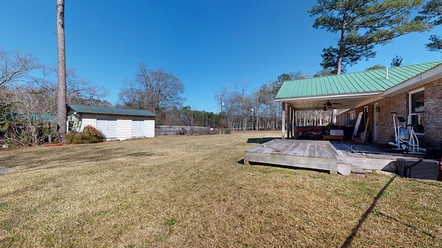 view of yard featuring an outbuilding, a storage unit, and ceiling fan