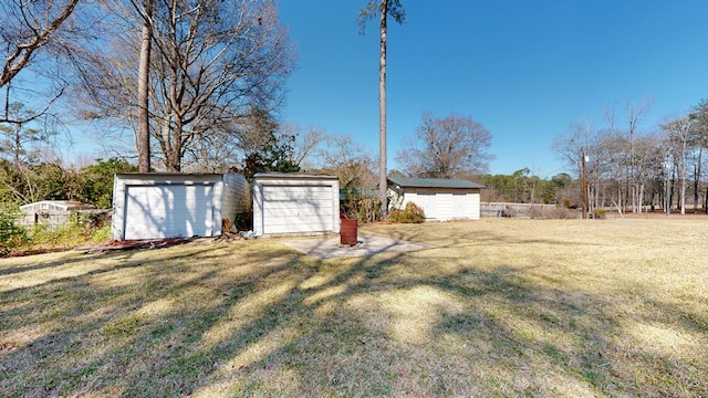 view of yard featuring an outbuilding, a storage unit, and a garage