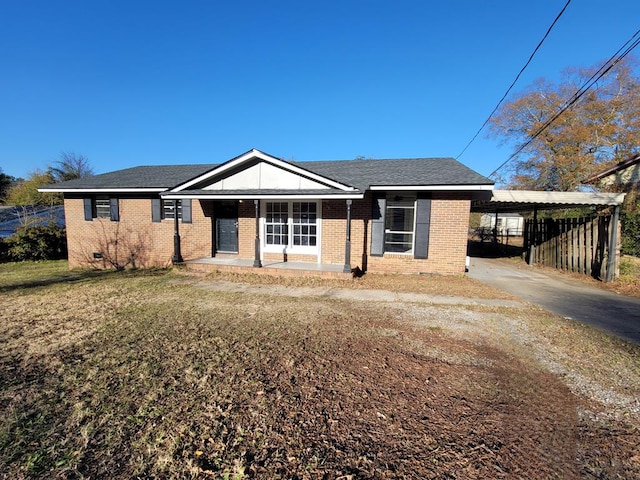 view of front facade featuring a porch, a carport, and a front lawn