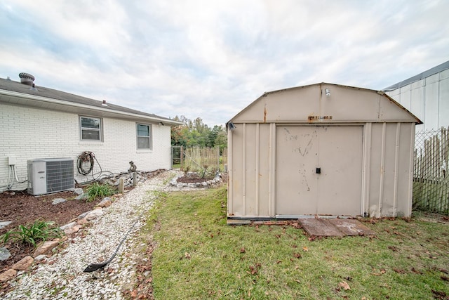 view of shed with central AC unit and fence