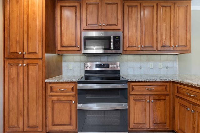 6215 Seaton Dr, Columbus, GA 31909 - kitchen featuring stainless steel appliances, brown cabinetry, decorative backsplash, and light stone counters