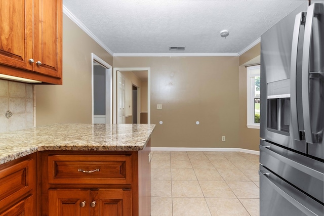6215 Seaton Dr, Columbus, GA 31909 - kitchen featuring stainless steel refrigerator with ice dispenser, decorative backsplash, brown cabinetry, light stone countertops, and light tile patterned floors