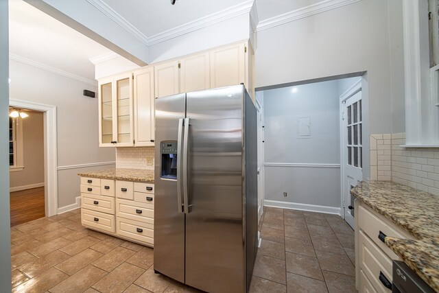 kitchen with light stone countertops, appliances with stainless steel finishes, tasteful backsplash, crown molding, and white cabinets