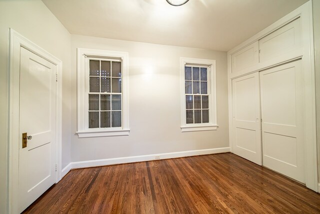 unfurnished bedroom with dark hardwood / wood-style flooring and a closet