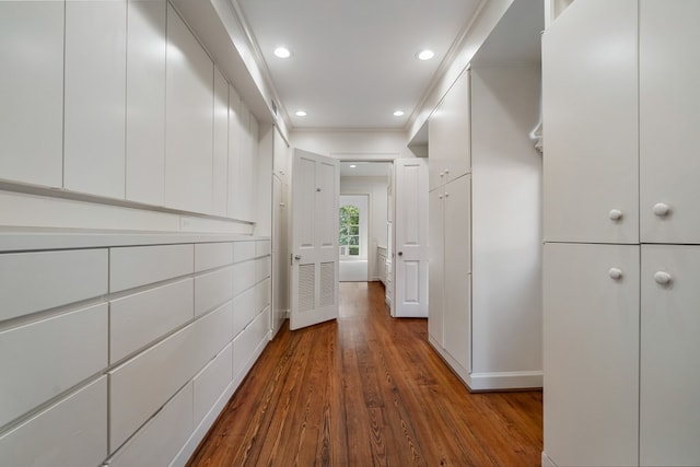 hall with dark wood-type flooring and ornamental molding