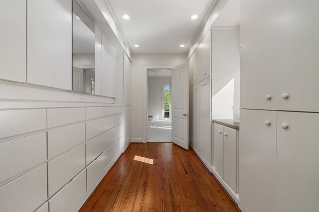 hallway with dark hardwood / wood-style flooring and ornamental molding