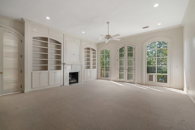 unfurnished living room featuring ceiling fan, light colored carpet, and ornamental molding