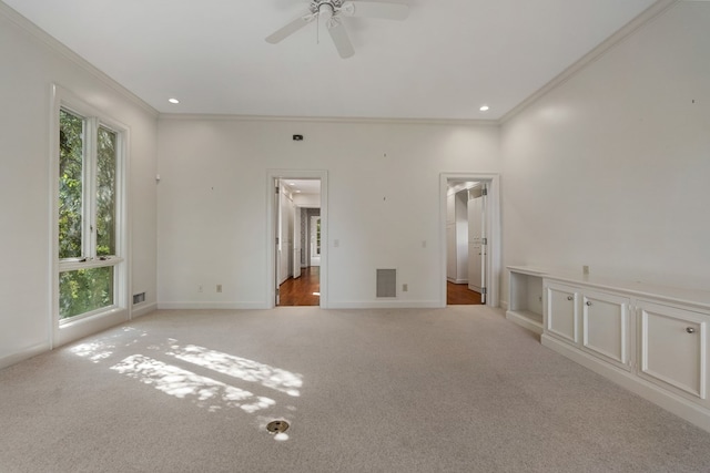 carpeted spare room with ceiling fan and ornamental molding