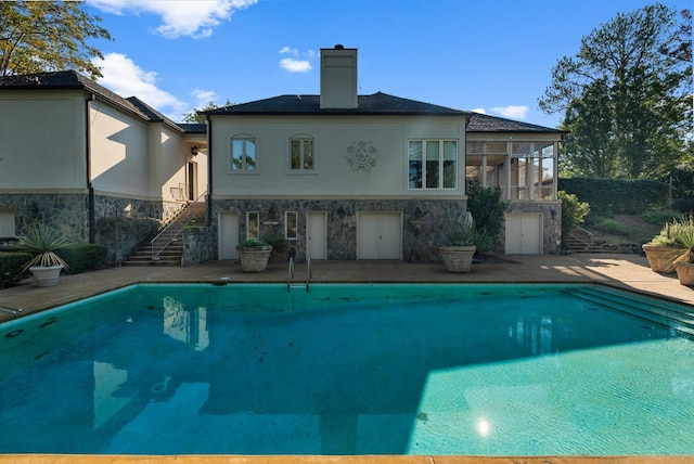 view of pool with a patio area and a sunroom