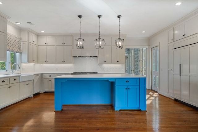 kitchen featuring decorative light fixtures, a kitchen island, and dark wood-type flooring