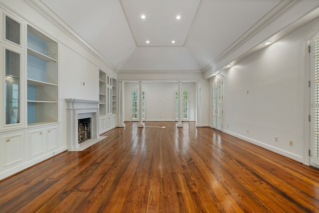 unfurnished living room featuring built in shelves, dark hardwood / wood-style flooring, vaulted ceiling, and ornamental molding