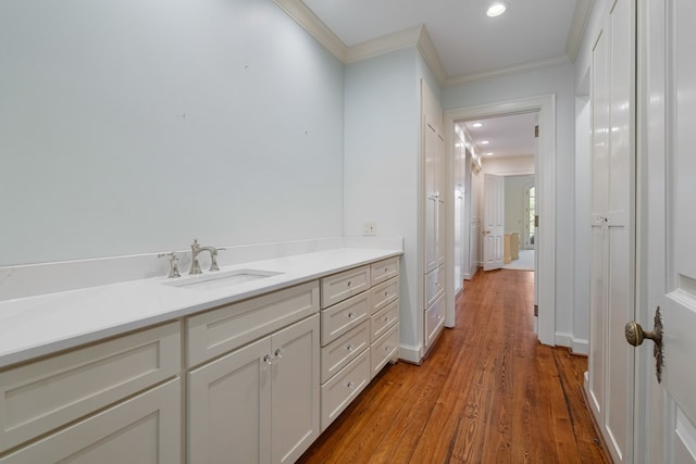 bathroom featuring hardwood / wood-style floors, vanity, and crown molding