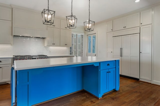 kitchen featuring dark hardwood / wood-style floors, decorative backsplash, ornamental molding, decorative light fixtures, and a kitchen island