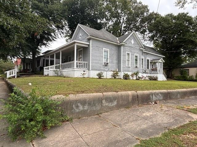 view of front of home with covered porch and a front lawn