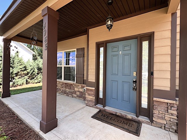 view of exterior entry with covered porch