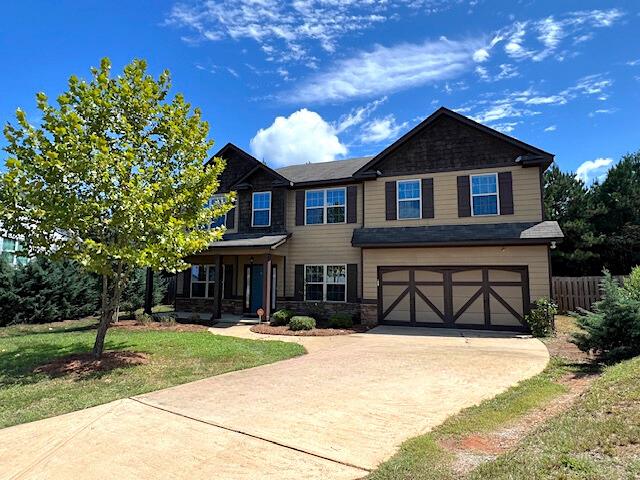 craftsman-style home featuring a front yard and a garage