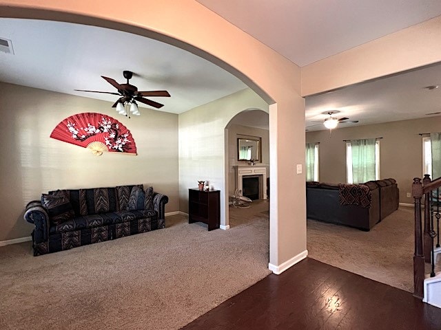 carpeted living room with ceiling fan