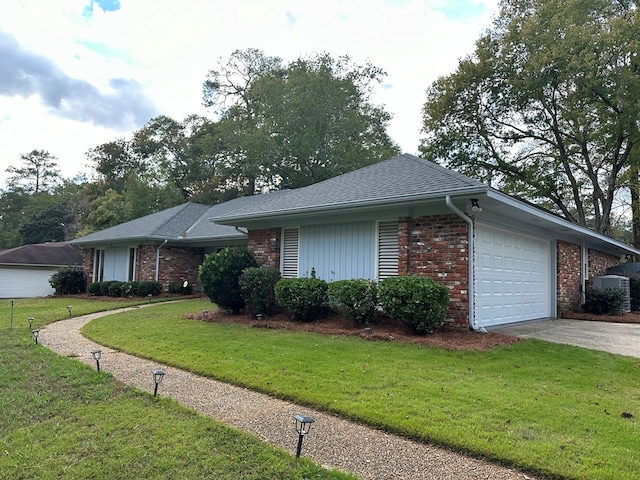 single story home with a garage, brick siding, driveway, and a front lawn