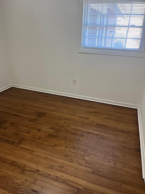 empty room featuring dark hardwood / wood-style flooring