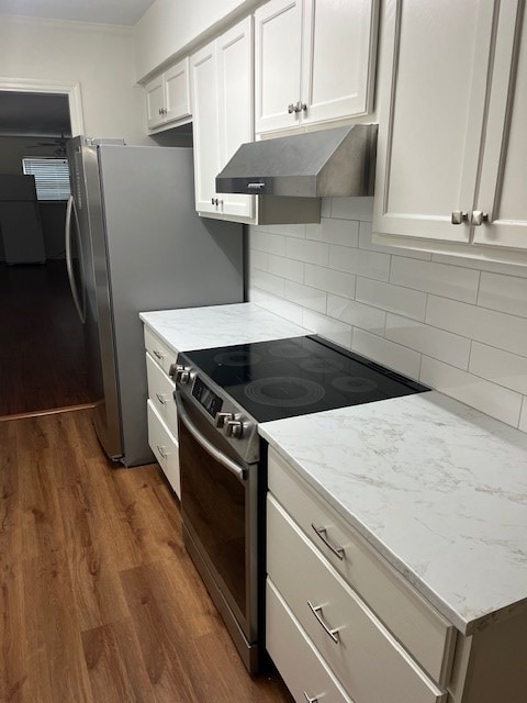 kitchen featuring stainless steel electric stove, decorative backsplash, white cabinetry, and dark wood-type flooring