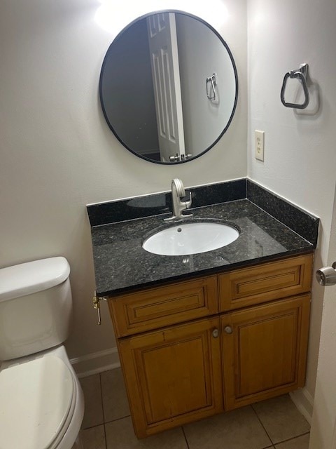 bathroom with tile patterned flooring, vanity, and toilet