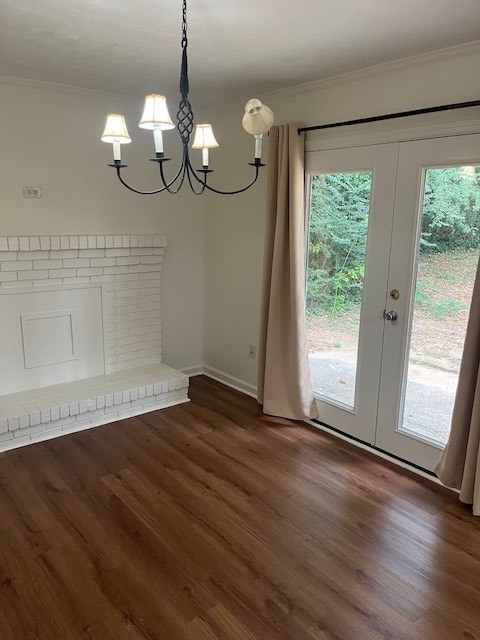 unfurnished dining area featuring dark hardwood / wood-style flooring, french doors, a chandelier, and ornamental molding