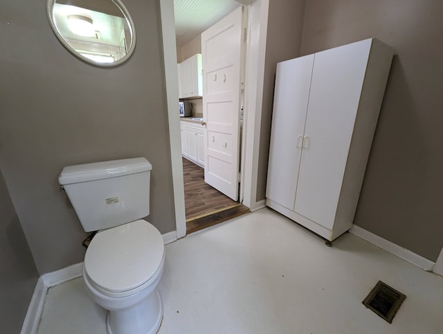 bathroom with toilet and concrete floors