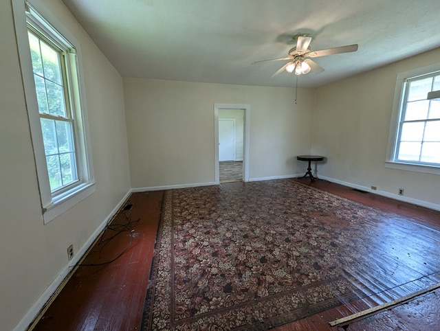 empty room with ceiling fan and dark wood-type flooring