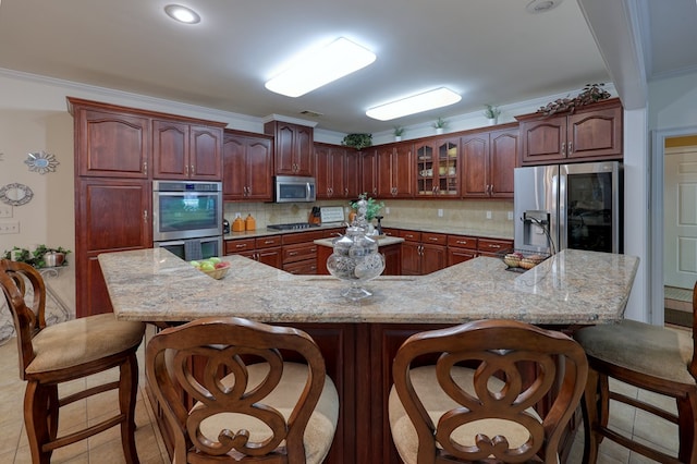 1000 Gramercy Dr, Midland, GA 31820 - kitchen with stainless steel appliances, a kitchen bar, tasteful backsplash, light tile patterned floors, and a large island