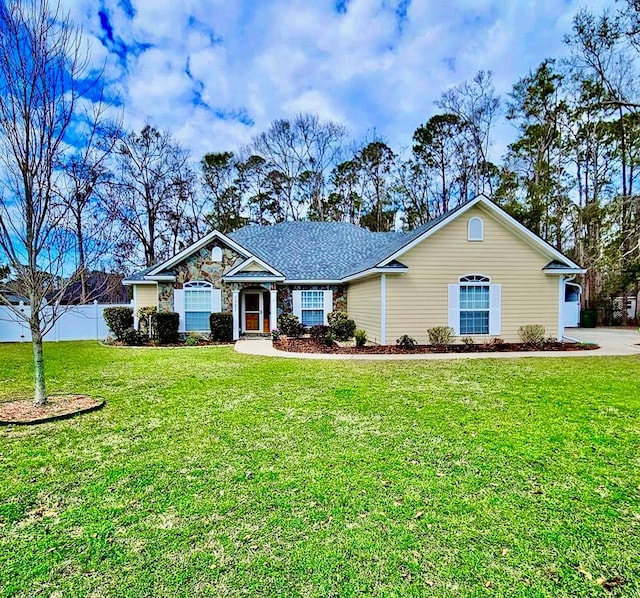 ranch-style home featuring stone siding, a front lawn, and fence