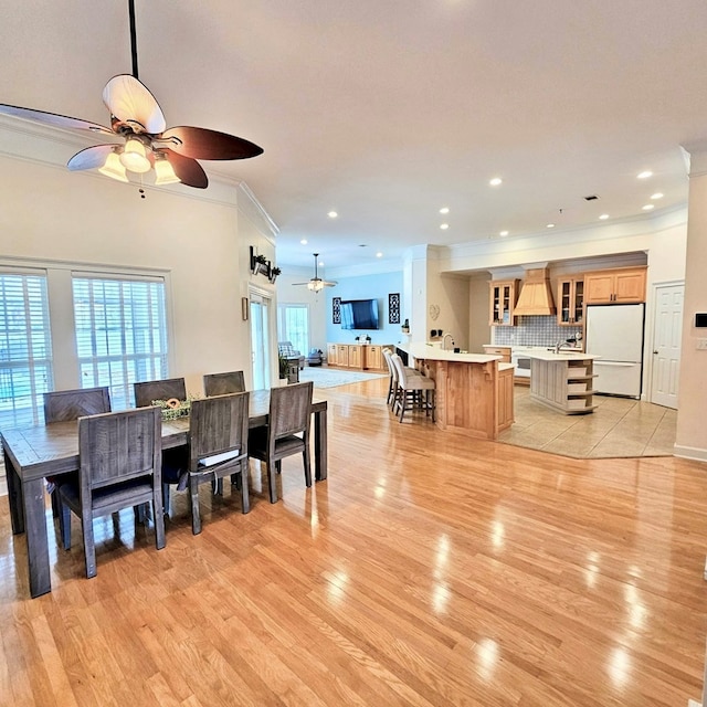 dining room featuring light wood-style floors, recessed lighting, crown molding, and a ceiling fan