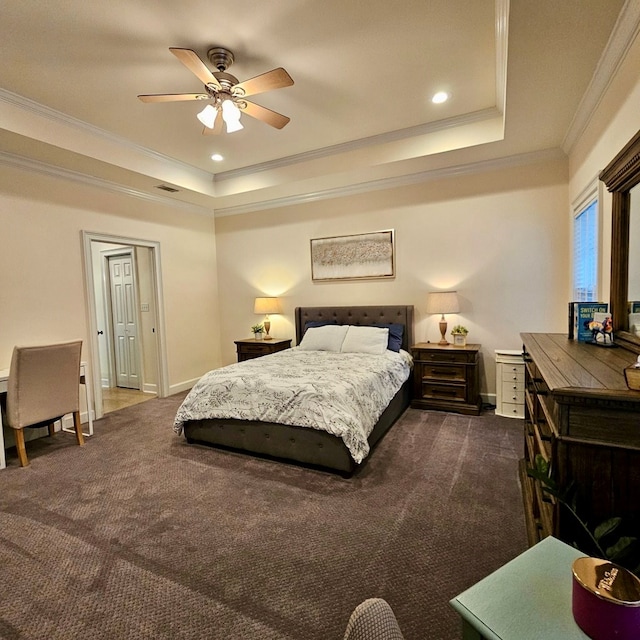 bedroom featuring ornamental molding, a tray ceiling, baseboards, and dark colored carpet