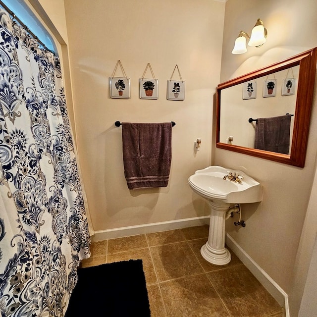 full bath with curtained shower, tile patterned flooring, and baseboards