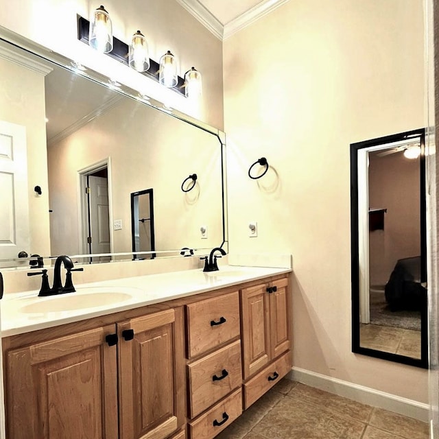 bathroom with double vanity, ornamental molding, a sink, and baseboards