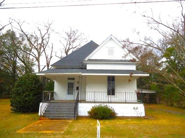 view of front of house with covered porch and a front lawn