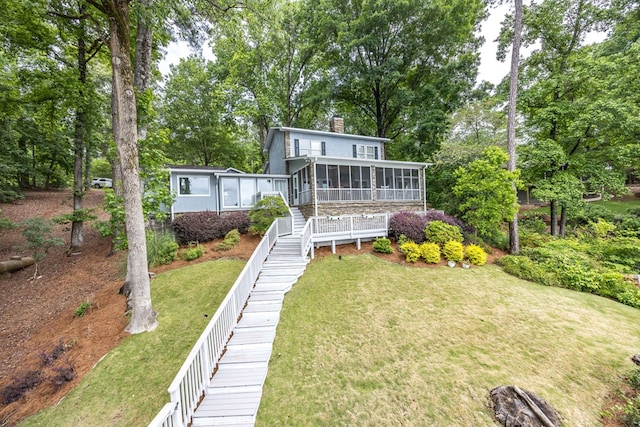 566 Longview Dr, Hamilton, GA 31811 - back of property with a sunroom, a chimney, a lawn, stairs, and view of wooded area