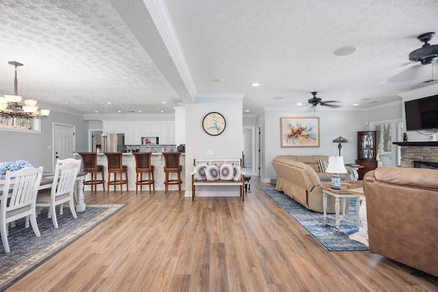 566 Longview Dr, Hamilton, GA 31811 - living room with light wood-style floors, a chandelier, a textured ceiling, a ceiling fan, and a fireplace