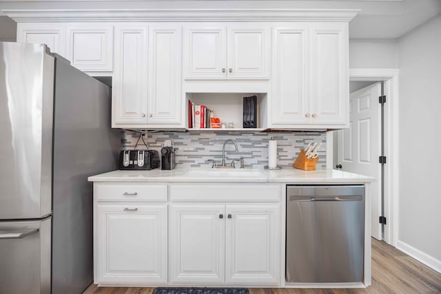566 Longview Dr, Hamilton, GA 31811 - kitchen featuring stainless steel appliances, a sink, backsplash, and white cabinets