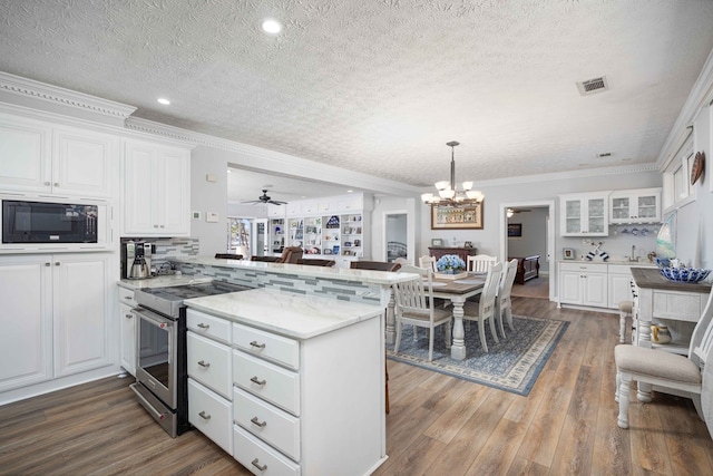 566 Longview Dr, Hamilton, GA 31811 - kitchen featuring electric stove, black microwave, a peninsula, a textured ceiling, and white cabinets