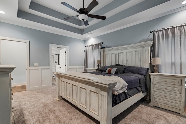 carpeted bedroom featuring a raised ceiling, ornamental molding, and ceiling fan