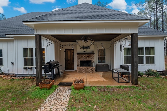 rear view of house featuring a yard, a fireplace, and a patio area