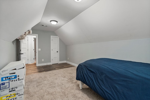 bedroom featuring hardwood / wood-style flooring and lofted ceiling