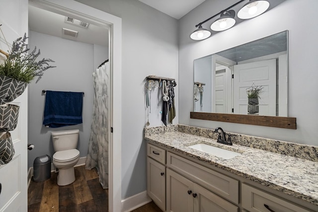 bathroom with wood-type flooring, vanity, and toilet