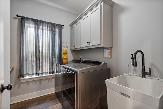 clothes washing area featuring sink, dark hardwood / wood-style floors, cabinets, and independent washer and dryer